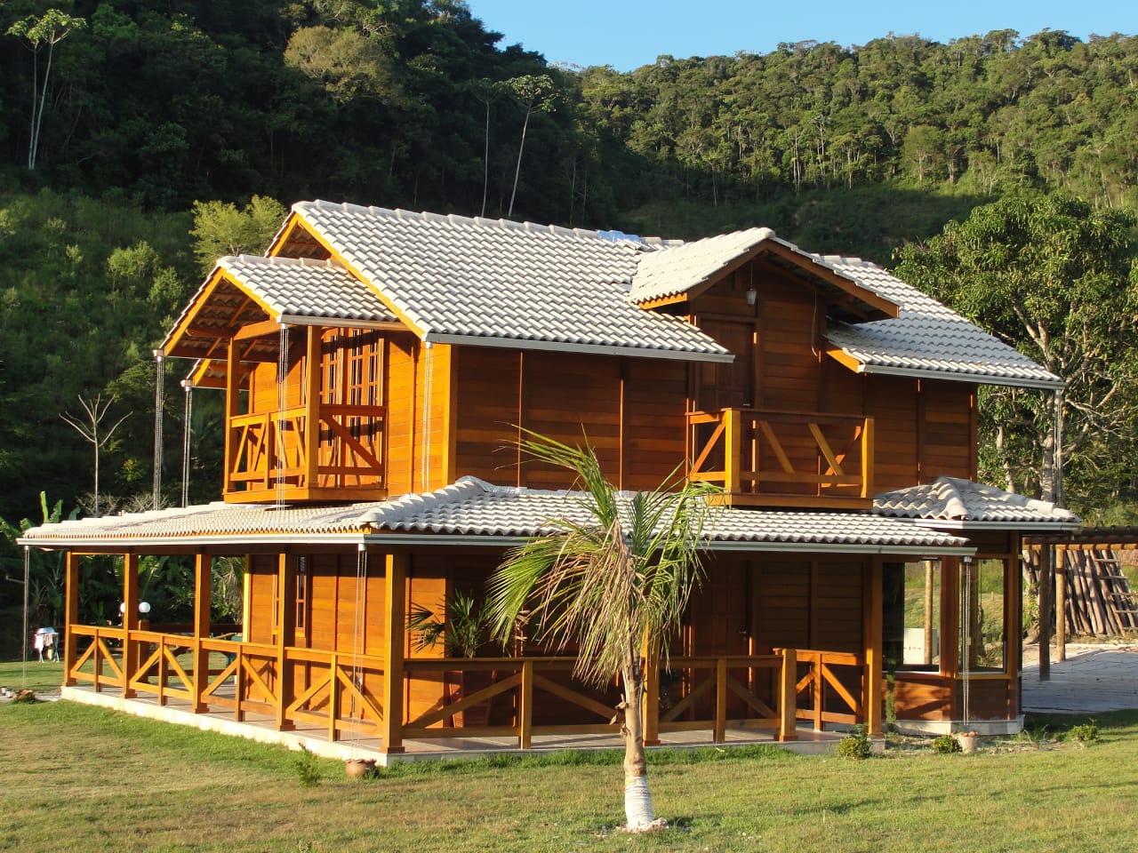 Casa de madeira de dois pavimentos com varanda ampla